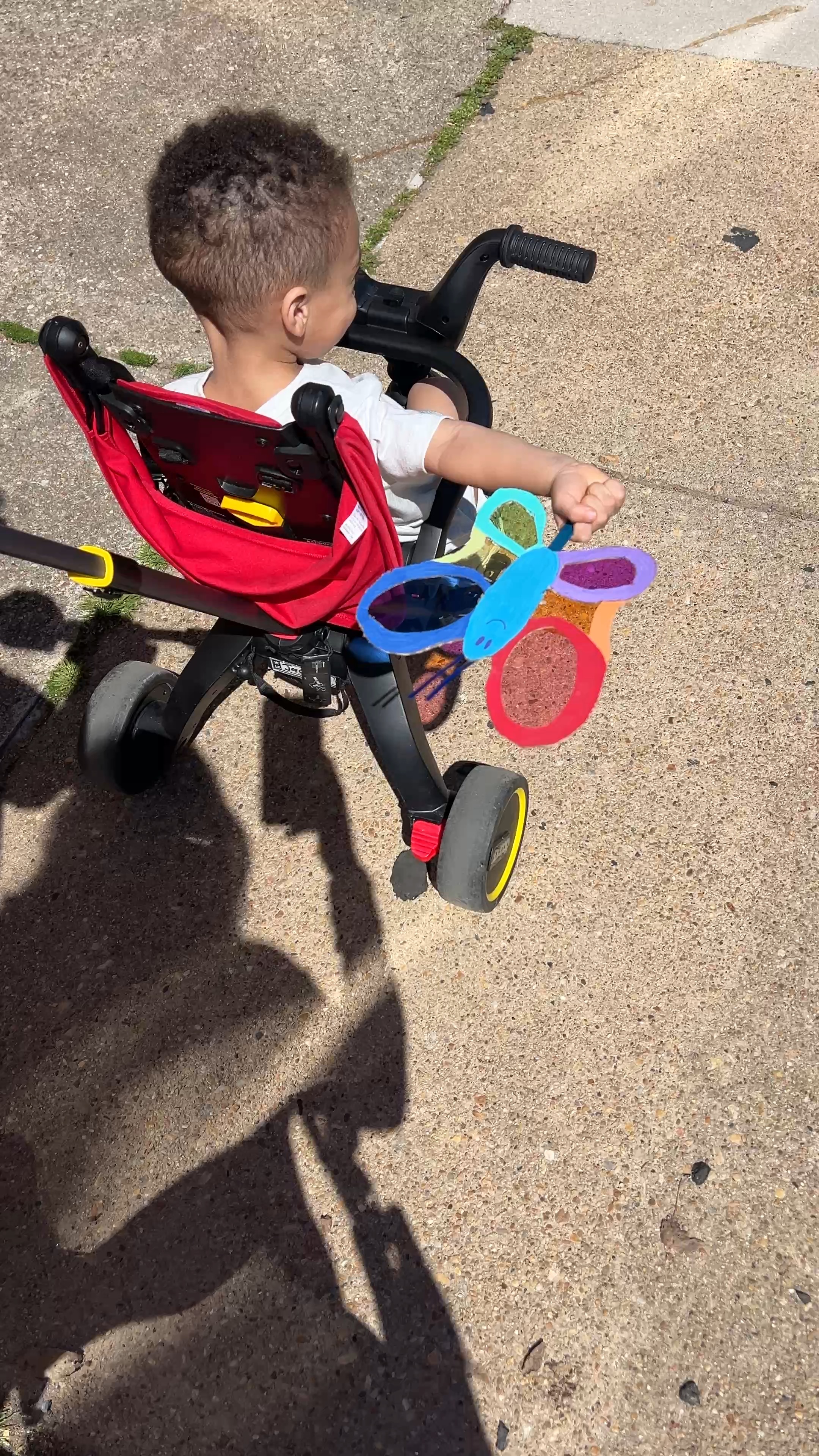 Child carrying a colorful butterfly project outside