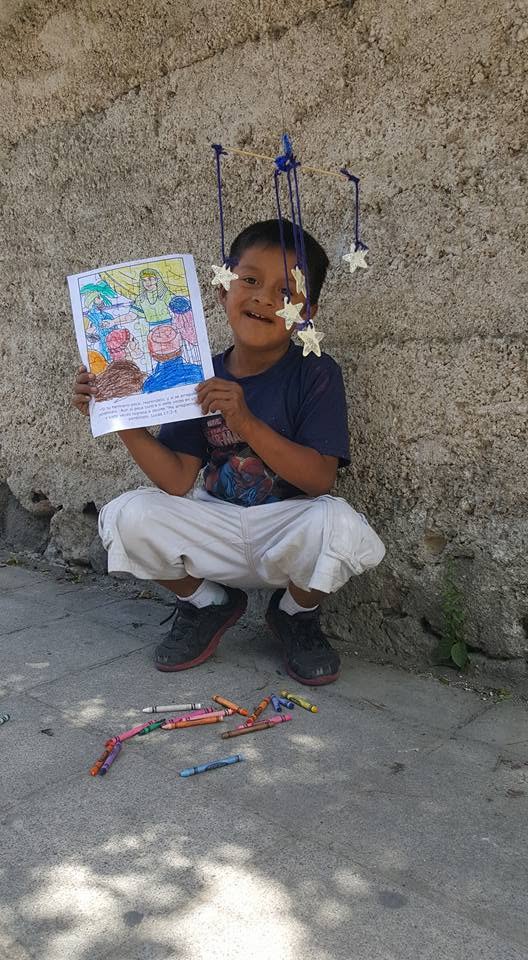 Child proudly holding a completed project