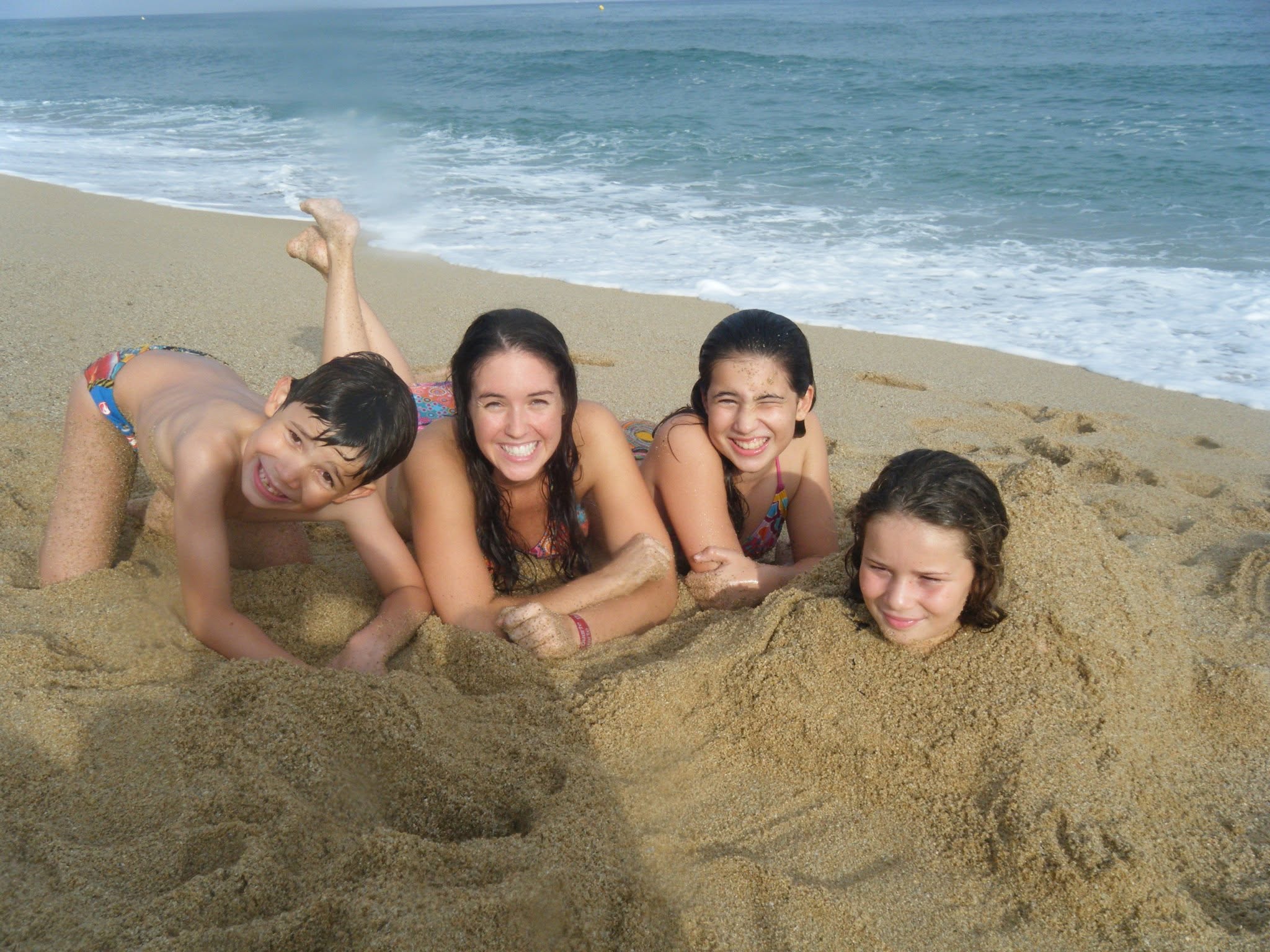 Nanny and children playing together at the beach